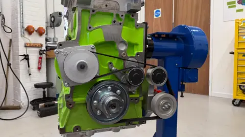 Danny Pike / BBC A green engine mounted on a blue stand.