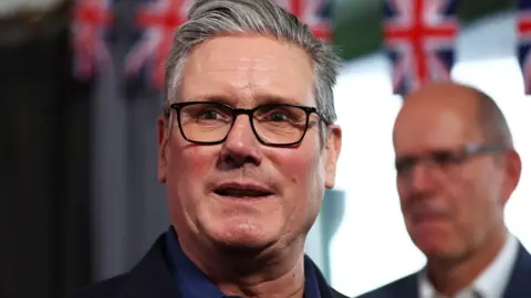 PA Media Sir keir Starmer standing in front of Union Jack bunting.