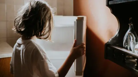 Getty Images Child looks into empty fridge