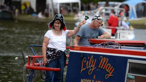 Bedford Borough Council Two people with pirate hats on standing on a barge, on the River Great Ouse, in Bedford