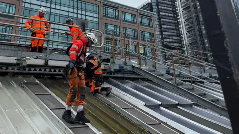 @BBCTomEdwards Men in hiviz are standing on the rood 