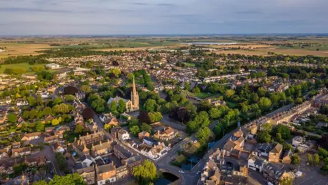 An aerial view of Spalding Town Centre south of the river including South Holland Centre, Church of St Mary and St Nicholas & River Welland.