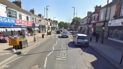 Newland Avenue in Hull. A busy high street with a zebra crossing and cars going by.