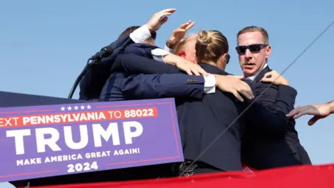 Getty Images Secret service agents surround Trump after Crooks' shot grazes his ear