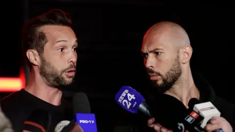 Tristan (left) and Andrew Tate speaking to members of the media in March 2025.