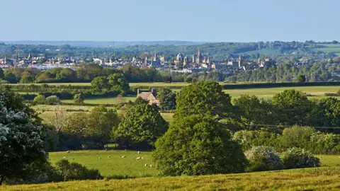 Getty Images The historic Oxford skyline is in the distance, with green countryside and sheep grazing in the foreground. 