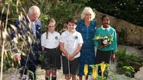 Getty Images The King and Queen with pupils from Sulivan Primary School