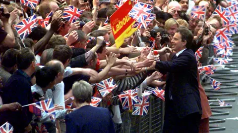 PA Media Tony Blair in Downing Street in 1997 shaking hands with a huge crowd of people.