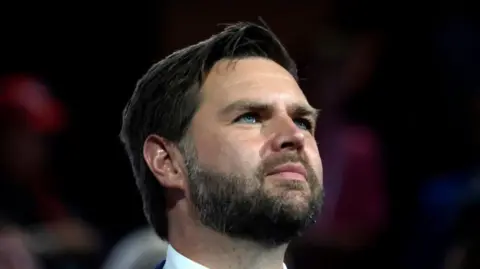 Eva Marie Uzcategui/Bloomberg via Getty Images Close up shot of JD Vance looking ahead with piercing blue eyes and dark beard and short hair combed to one side 