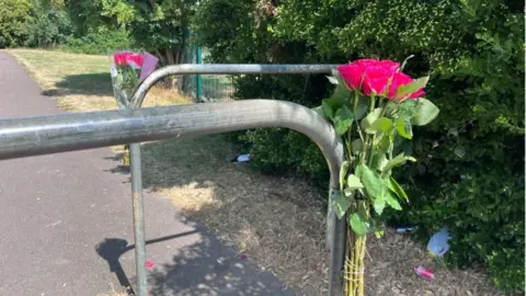 Two bunches of pink flowers attached to railings.