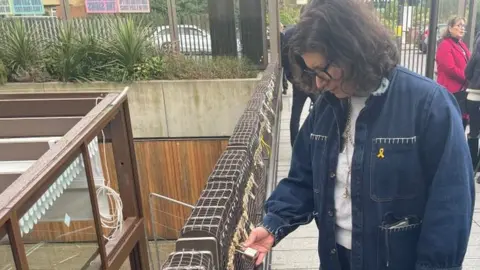 Tom Grundy/BBC Dr Sharone Lifschitz fixing a padlock for her father who is being held hostage