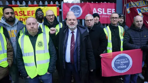 Mick Whealen, general secretary of the Aslef union, stands on a picket line with train drivers on strike