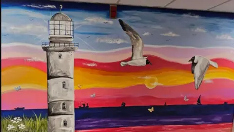 Lincolnshire NHS Charity Another wall featuring a colourful sunset, a lighthouse and birds