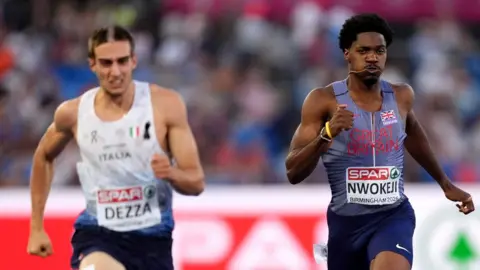 PA Media An Italian athlete in a white vest narrowly beats Nwokeji across the line during a race.