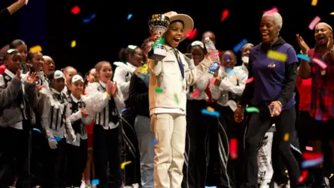 A Boroughs United winner on stage at the Hackney Empire