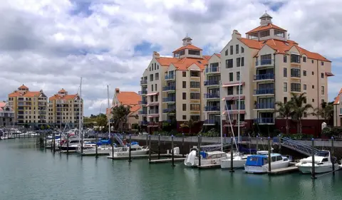 Getty Images Several apartments with orange roofs by a marina 