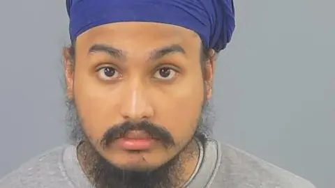 Vickrum Digwa, a man with a beard, a grey jumper and a purple turban looking to the camera.