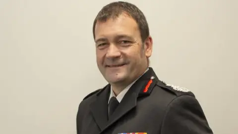 Derbyshire Fire and Rescue Service A head and shoulder picture of Gavin Tomlinson in his firefighter's formal uniform 