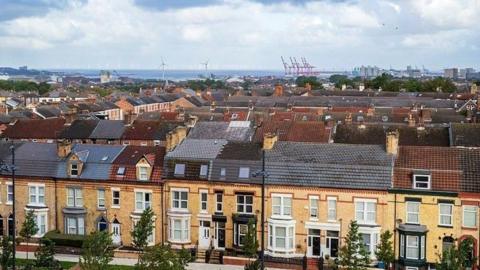 Terraced houses in Liverpool, against a backdrop of the docks and the River Mersey