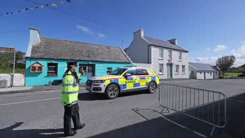 PA Gardaí (Irish police) stood guard in Doonbeg as the village awaited the famous guest