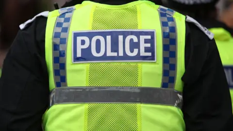 A generic image of a police officer wearing a hi viz vest with 'police' on the back.