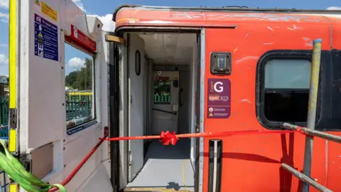 Upshire Primary Foundation School The door of a train carriage with a ribbon tied in front of the door.