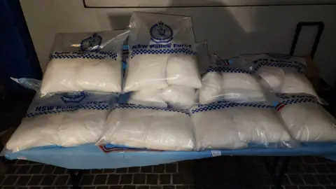 Several bags containing white powder sitting on a table.