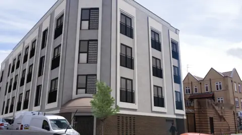 Landrose A computer generated artist's impression showing how the new flats on Church Road will look. It shows a large three-storey modern building positioned above a pub on a street corner. It is white and grey with lots of windows, which each have black Juliet balconies overlooking the road below.