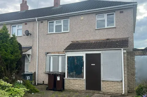 Close up of a boarded up prefab house