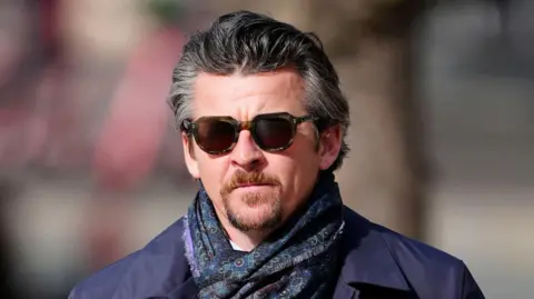 PA Media Joey Barton, wearing dark sunglasses, walking outside the court