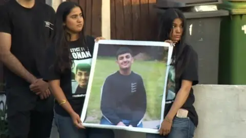 BBC Two girls holding a photo of Ronan Kanda