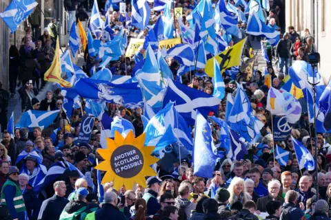 PA Media Thousands of activists wave saltire flags