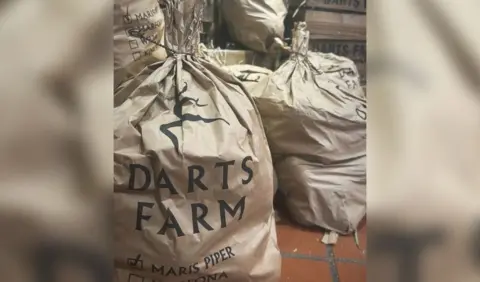 BBC Several bags of potatoes with a green Darts Farm logo printed on the side.