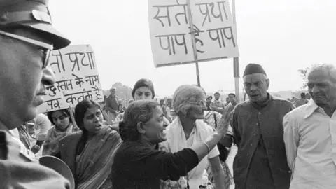 Getty Images Um grupo de grupos de mulheres progressistas protestou em Nova Deli, em 11 de novembro de 1987, contra a tradição ultrapassada em algumas comunidades hindus de forçar as viúvas a cometer sati – sentar-se na pira funerária do marido e queimá-lo. (Foto de Sondeep Shankar/Getty Images)