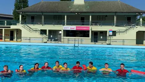 Vivacity A number of lifeguards in the pool at Peterborough Lido, smiling for the camera.
