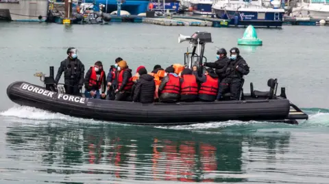 Asylum seekers wearing life jackets arriving into Dover docks on a Border Force RIB after being rescued in the English Channel (stock image)