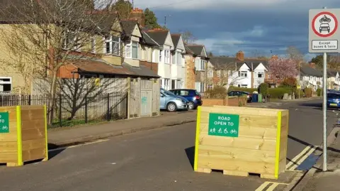 Oxfordshire County Council Two wooden road blocks with signs on saying the road is open to pedestrians, scooters, wheelchairs and cyclists