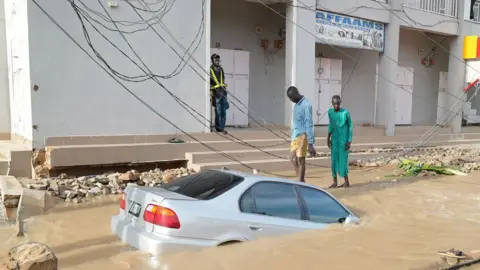 Gift Ufuoma / BBC A car sunk in flood water in Maiduguri, Nigeria