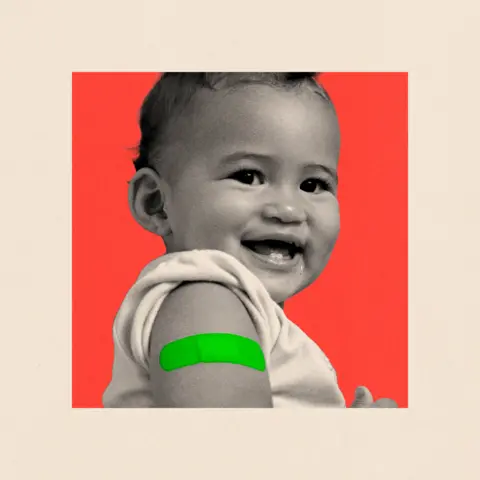 BBC Close up of a baby smiling with a plaster on their arm.