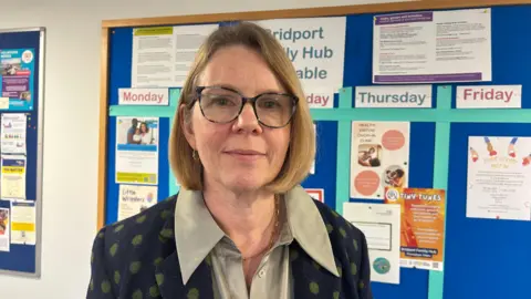 A female doctor wearing a navy blue jacket with green spots