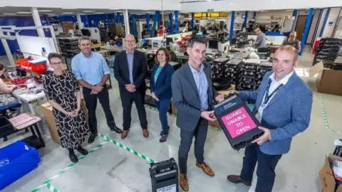 Cornwall Council Councillor Louis Gardiner, far right, with Tony Westington, managing director of Secure Innovation. Pictured behind (left to right) are Secure Innovation's Lorraine Gunton, Jason Gibbs, Martin Pascoe, and Hazel Gosling