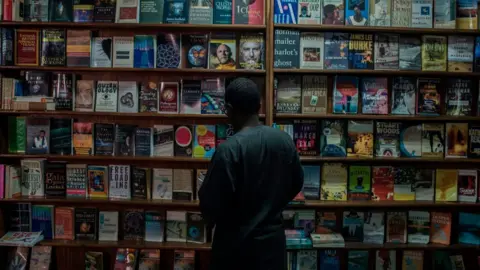 AFP Kunle Tejuoso, owner of The Jazz Hole organizes bookshelves on January 30, 2018. The Jazz Hole is an independent record and book store in Lagos.
