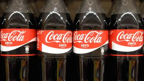 Newscast Coca-cola bottles on shelf