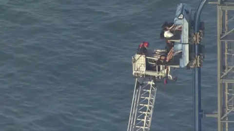 Firefighers rescue the trapped riders.