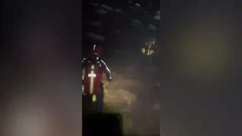 KMRT Headcam footage from one of the rescue teams, showing members walking in line through darkness, high winds and snow