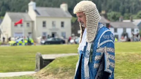 BBC Skelly in the President's elaborately decorated blue and silver robes and white wig.