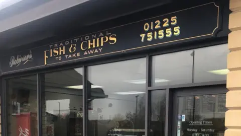 Philip Robinson Front of the fish and chip shop with a sign saying "Robinson's Traditional Fish and Chips to take away" and their telephone number