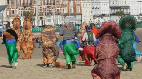 We Are Weymouth Dinosaurs on a beach