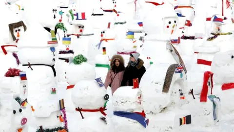 Reuters A couple walk between snowmen on Songhua River that displays 2019 snowmen as a part of annual ice festival, in the northern city of Harbin