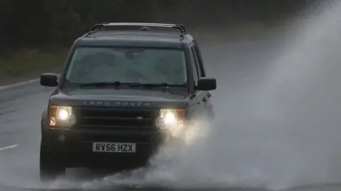 Gareth Fuller A car drives through a large puddle on the A20 in Folkestone, Kent